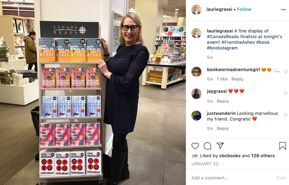 Instagram photo. A white woman with blonde hair stands next to a bookcase in a Chapters.